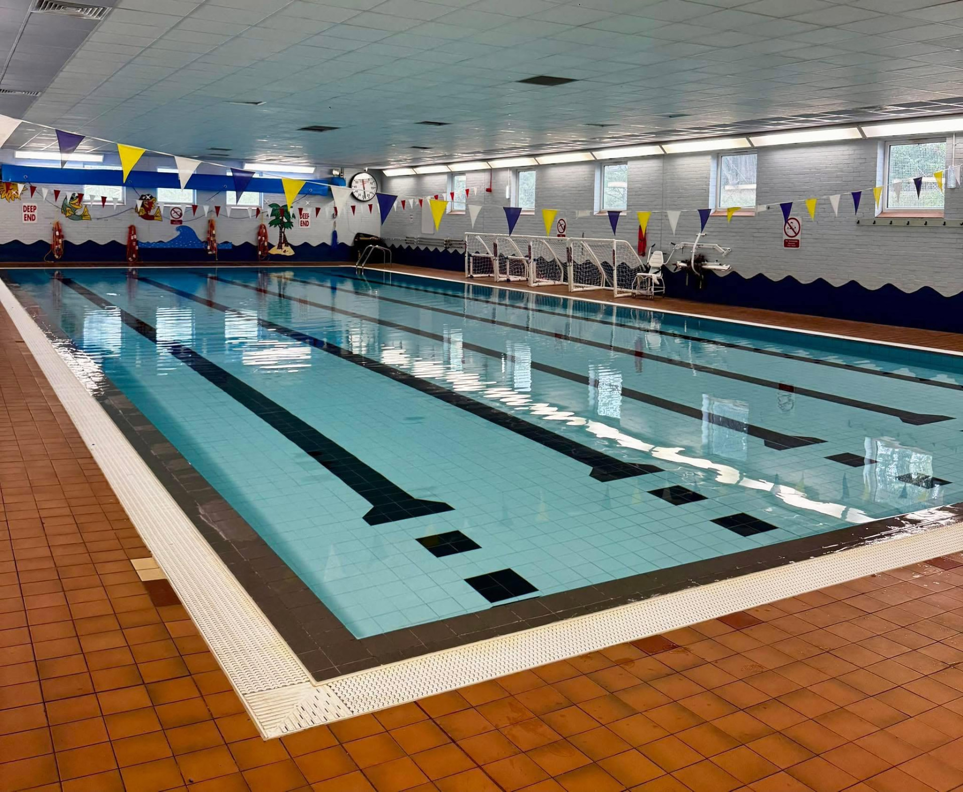 The indoor swimming pool at Chippindale Pool, with marked lanes and bunting above the water